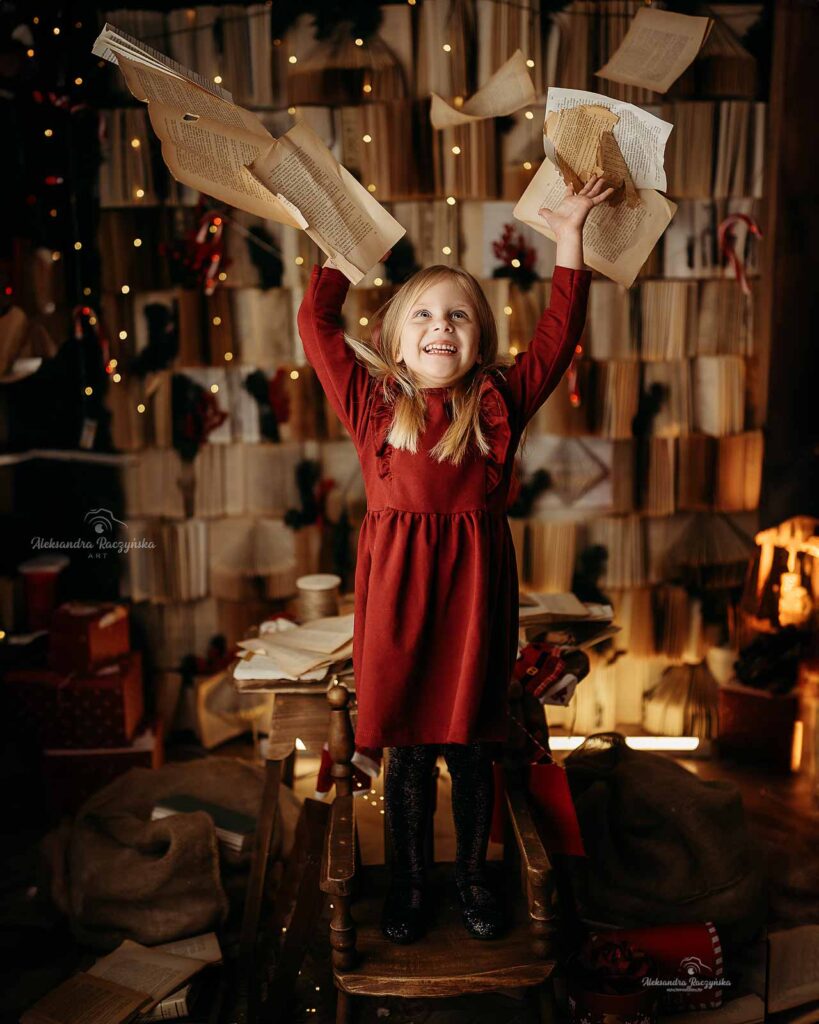 Dziecko, tło książki w studio Drugi Brzeg w Warszawie – świąteczna sesja fotograficzna w klimacie Bożego Narodzenia.