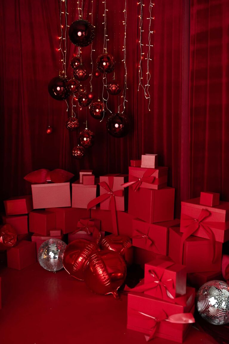 Piękna aranżacja świąteczna w Studio Drugi Brzeg, czerwona wraz z prezentami i bombkami