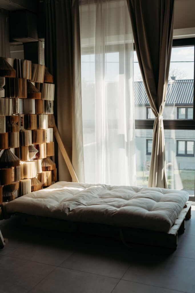 Studio fotograficzne wynajem – scenka z materacem na podłodze, światło dzienne, ściana z książkami, Warszawa